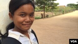 កុមារី​គុល ស្រីម៉ៅ ឈរ​នៅ​មុខ​សាលារៀន​របស់​នាង​ដែល​លោកស្រី Michelle Obama ភរិយា​ប្រធានាធិបតី​សហរដ្ឋ​អាមេរិក បាន​ទៅ​ធ្វើ​ទស្សនកិច្ច​នៅ​ខែមីនា​ឆ្នាំ២០១៥ ដើម្បី​ផ្សព្វផ្សាយ «គម្រោង​ផ្តល់​ឱកាស​ឲ្យ​ក្មេង​ស្រី​បាន​សិក្សា» «Let Girls Learn»។