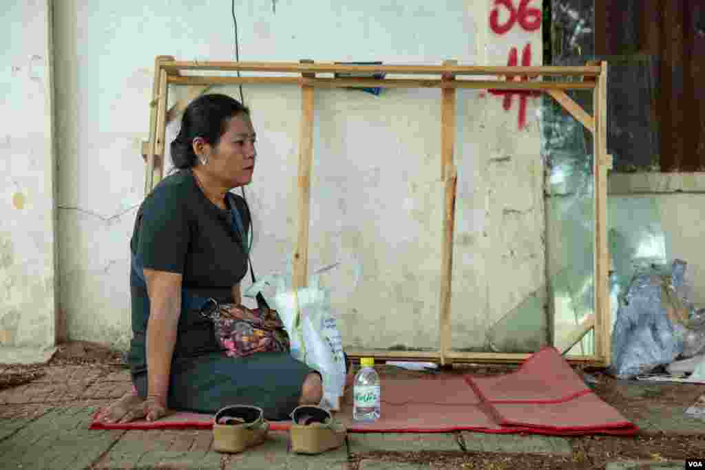  អ្នកស្រី ស្រ៊ឺ ឆាយឡេង អាយុ ៤៥ឆ្នាំ សម្រេចមកអង្គុយចាំកូនស្រីដែលកំពុងប្រឡងសញ្ញាបត្រមធ្យមសិក្សាទុតិយភូមិទាំងពីរថ្ងៃ នៅក្បែរមណ្ឌលប្រឡងវិទ្យាល័យឥន្ទ្រទេវី ដើម្បីមកលើកទឹកចិត្តកូនស្រីរបស់ខ្លួន កាលពីព្រឹកថ្ងៃទីពីរ ដែលជាថ្ងៃចុងក្រោយនៃការប្រឡងសញ្ញាបត្រមធ្យមសិក្សាទុតិយភូមិ នៅរាជធានីភ្នំពេញ នៅថ្ងៃទី២០ ខែសីហា ឆ្នាំ២០១៩។ (ប៊ុន សុខា/VOA)
