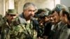 FILE - Rashid Dostum shakes hands with local residents in Shebergan, Afghanistan,, Dec. 27 , 2001. 