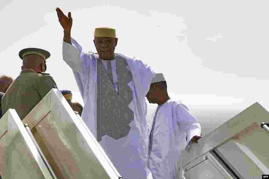 L'ex-président malien Amadou Toumani Touré salue en sortant de l'avion à Bamako, le 24 décembre 2017.