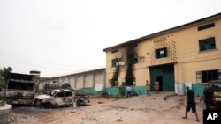 Des véhicules incendiés devant une prison à Owerri, au Nigeria, le 5 avril 2021, après que des centaines de détenus se soient évadés de l'établissement.
