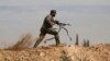 FILE - A Shi'ite fighter clashes with members of the Sunni-dominated Free Syrian Army rebel in the town of Hatita, in the countryside of Damascus, Syria, Nov. 22, 2013.