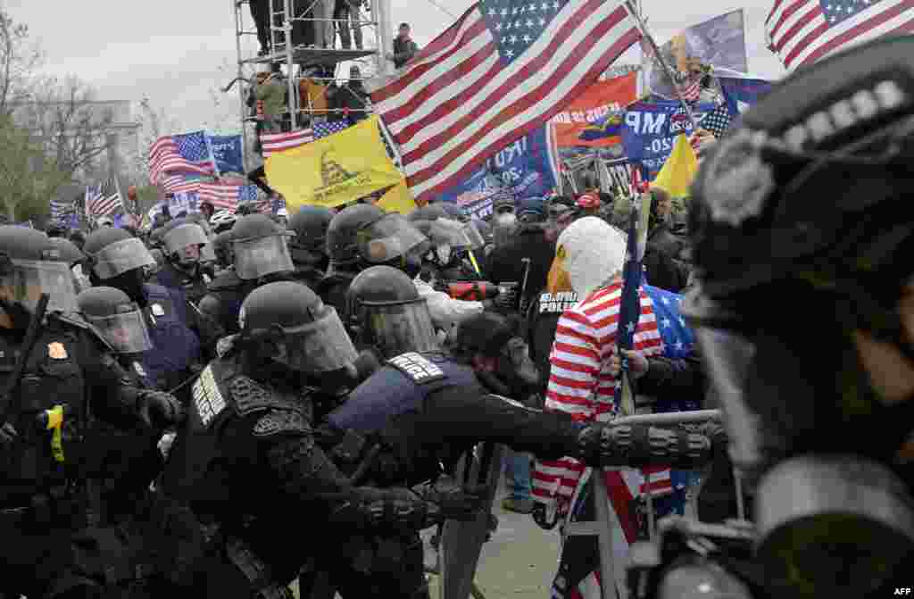 Les partisans de Trump se heurtent à la police et aux forces de sécurité alors qu'ils tentent de prendre d'assaut le Capitole américain entouré de gaz lacrymogènes à Washington DC, le 6 janvier 2021. (Photo par Joseph Prezioso / AFP)