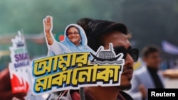 民眾2024年1月4日手持支持現任總理謝赫·哈西娜（Sheikh Hasina）的宣傳牌。（路透社）
