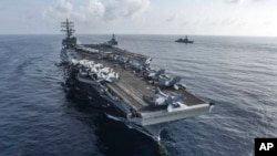 美國海軍的里根號航空母艦和米利厄斯號導彈驅逐艦﹐與日本海上自衛隊2018年8月在南中國海進行聯合演習 (資料圖片)