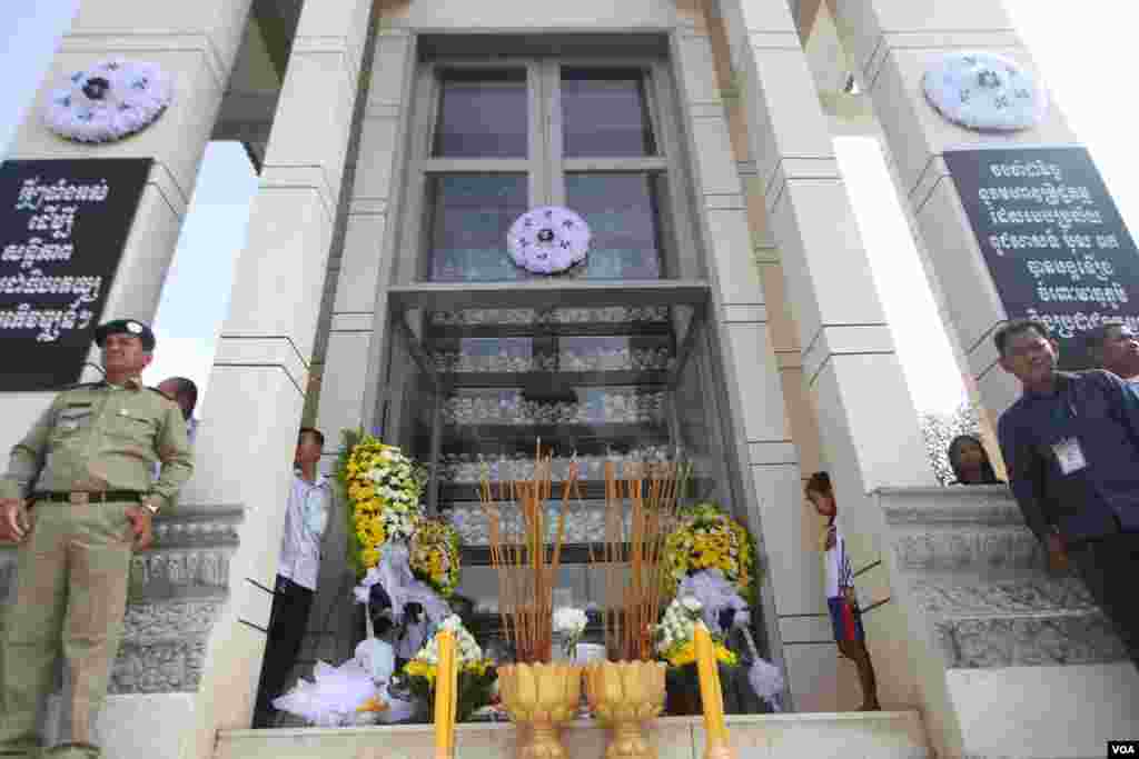បុរសពីរនាក់ឈរអមនៅមុខក្បាលអ្នកដែលបានស្លាប់នៅរបបប្រល័យពូជសាសន៏ប៉ុល ពតនៅវាលពិឃាដជើងឯកនៃរាជធានីភ្នំពេញនៅថ្ងៃទី២០ឧសភា ២០១៦នេះក្នុងទិវា«ចងកំហឹង»ដើម្បីរំលឹកដល់វិញ្ញានក្ខ័ណ្ឌអ្នកដែលស្លាប់នៅរបបប្រល័យពូជសាសន៏ចាប់ពីឆ្នាំ១៩៧៥ដល់១៩៧៩។( ឡេង ឡែន/VOA)