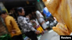 រូប​ឯកសារ៖ មាន់​​មួយ​ក្បាល​​ត្រូវ​បាន​ព្យួរ​សម្រាប់​លក់​នៅ​​ផ្សារ​មួយ​ក្នុង​រាជធានី​ភ្នំពេញ កាល​ពី​ឆ្នាំ​២០១៣។