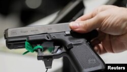 Un homme porte un pistolet à la main pendant la convention annuelle de la NRA à Dallas, Texas, mai 6, 2018. 