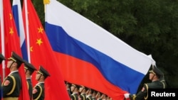 中國軍人在北京人大會堂外為中國國家主席習近平歡迎俄羅斯總統普京而舉行的儀式做準備。 （2018年6月8日）
