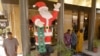 Des musulmans assistent à la prière du vendredi après-midi à côté d'un Père Noël gonflable près d’une boulangerie dans le centre de Dakar, au Sénégal, 16 décembre 2005.