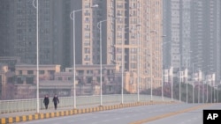 中國武漢市，人戴著口罩在街道上行走。（2020年1月28日）