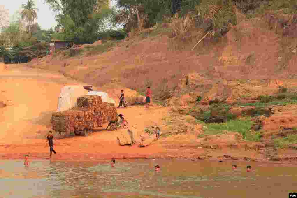ក្មេងៗលេងទឹកនៅក្បែរកំពង់ចម្លងមួយក្នុងស្រុកឈ្លូង ខេត្តក្រចេះនៃប្រទេសកម្ពុជា នៅថ្ងៃទី១៦ ខែមិនា ឆ្នាំ២០១៤។ (នូវ ពៅលក្ខិណា)