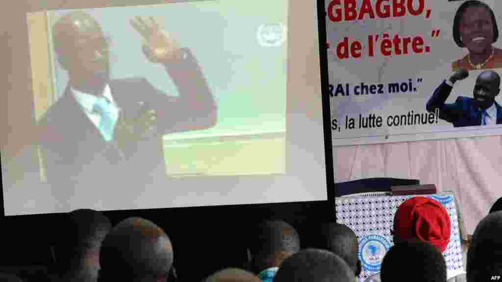 Des membres des "Jeunes Patriotes", un groupe de soutien à l'ancien président Côte d'Ivoire, Laurent Gbagbo, suivent, sur un grand écran, les procédures judiciaires de leur ancien Charles Blé Goudé lors de son audition à la Cour pénale internationale (CPI), à Koumassi, un quartier d’Abidjan, 2 octobre 2014
