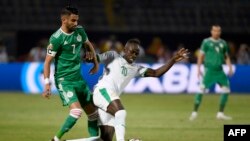 L'attaquant algérien Riyad Mahrez (à gauche) se bat pour le ballon avec l'attaquant sénégalais Sadio Mané lors du match de football de la Coupe d'Afrique des Nations (CAN) 2019 entre le Sénégal et l'Algérie au stade du 30 juin au Caire, le 27 juin 2019. 