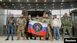 ARCHIVES - Des visiteurs posent pour une photo à l'extérieur du PMC Wagner Center, lors de l'ouverture officielle de l'immeuble de bureaux à Saint-Pétersbourg, en Russie, le 4 novembre 2022.