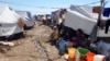 FILE - Displaced families, who fled from Islamic State violence in Mosul, sit at a refugee camp in Iraq, Oct. 22, 2014.