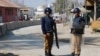 Policemen keep guard near the central prison where a court convicted 31 people over the campus lynching of a university student last year who was falsely accused of blasphemy, in Haripur, Pakistan, Feb. 7, 2018.