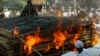 Cambodian officials inflame a pile of old guns collected nationwide during a weapon burning ceremony led by the government, in Kandal province, about 15 kilometers (9 miles), south of the capital Phnom Penh, Cambodia, Tuesday, June 20, 2006. (AP Photos/Heng Sinith)