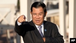 រូបឯកសារ៖ លោក​នាយក​រដ្ឋមន្ត្រី ហ៊ុន​ សែន លើក​ដៃ​ចង្អុល ខណៈពេល​ដែល​លោក​ត្រៀម​ថតរូប​រួម​គ្នា​ជាមួយ​នឹង​មេដឹកនាំ​ប្រទេស​ផ្សេងៗ ដែល​ចូលរួម​កិច្ច​ប្រជុំអាស៊ីអ៊ឺរ៉ុប​លើក​ទី១១ នៅ​ទីក្រុងអ៊ូឡង់បាទ័រ ប្រទេស​ម៉ុងហ្គោលី កាលពីថ្ងៃសៅរ៍ ទី១៦ ខែកក្កដា ឆ្នាំ២០១៦។ (AP Photo/Mark Schiefelbein)