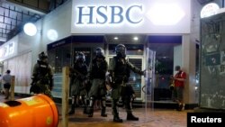 在香港反送中抗議之際，防暴警察站在灣仔街區一家匯豐銀行支行的大門外。 （2019年8月11日）