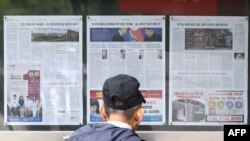 首爾街頭一名男子閱讀佈告欄上的新聞報道，關於北韓向烏克蘭前線部署數千名士兵的決定。 (法新社：2024年10月21日)
