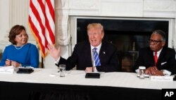 President Donald Trump joined by New Mexico Gov. Susana Martinez, left, and Vicksburg, Miss., Mayor George Flaggs, Jr., right, speaks in the State Dining Room of the White House, Feb. 12, 2018, during a meeting with state and local officials about infrastructure.