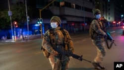 Les forces de défense sud-africaines patrouillent dans le centre-ville de Johannesburg, en Afrique du Sud, le vendredi 27 mars 2020. 