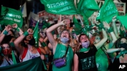 Des militants des droits à l'avortement regardent en direct la vidéo en streaming des législateurs en session, à Buenos Aires, en Argentine, le 30 décembre 2020. 