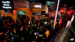 Medics and firefighters work outside Gandhi hospital after a fire erupted on multiple floors of the hospital in northern Tehran, Iran, on Jan. 25, 2024.