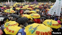 2019年6月9日在中國香港，示威群眾要求當局廢除擬議中的把犯人引渡到中國的法案。他們手持黃色遮陽傘，這是過去的佔領中環運動的象徵。 