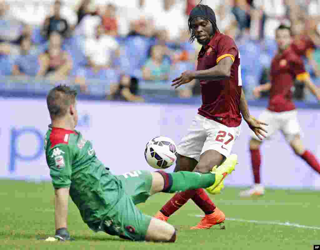 Alessio Cragno, gardien de but de Cagliari, se défend contre une percée de Gervinho de Roma, à droite, lors d'un match de football de Série A entre Roma et Cagliari, au Stade olympique de Rome, dimanche 21 septembre 2014.