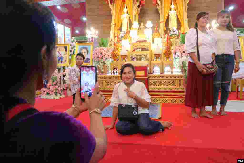ពលរដ្ឋខ្មែរដែលកំពុងធ្វើការនៅប្រទេសថៃ កំពុងថតរូបក្នុងពិធីបុណ្យភ្ជុំបិណ្ឌ នៅវត្តស៊ីសុដារ៉ាម ក្នុងទីក្រុងបាងកក នៅថ្ងៃទី២២ ខែកញ្ញា ឆ្នាំ២០១៩។ (កាន់ វិច្ឆិកា/VOA)