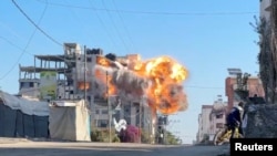Moshi na moto watanda kutoka jengo lililoharibiwa na shambulizi la Israel katika kambi ya wakimbizi ya Nuseirat, katika Ukanda wa Gaza, Novemba 28, 2024. Picha ya Reuters