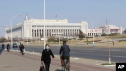 មនុស្សម្នា​ដើរ​កាត់​អគារ Presidium of the Supreme People's Assembly នៅ​ក្នុង​ក្រុង​ព្យុងយ៉ាង កាលពី​ថ្ងៃទី៩ ខែមេសា ឆ្នាំ២០២០។