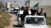 FILE - Free Syrian Army fighters head a convoy of vehicles carrying humanitarian supplies as they enter Damascus, March 20, 2014.