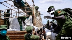 Des membres de l'Unité de défense locale déchargent des vivres destinés aux populations touchées par le confinement à Kampala, en Ouganda, le 4 avril 2020. (Photo: Reuters)