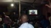 Des Congolais regardent la télévision pendant que le Président Félix Tshisekedi prononce son discours à Kinshasa, le 6 décembre 2020.