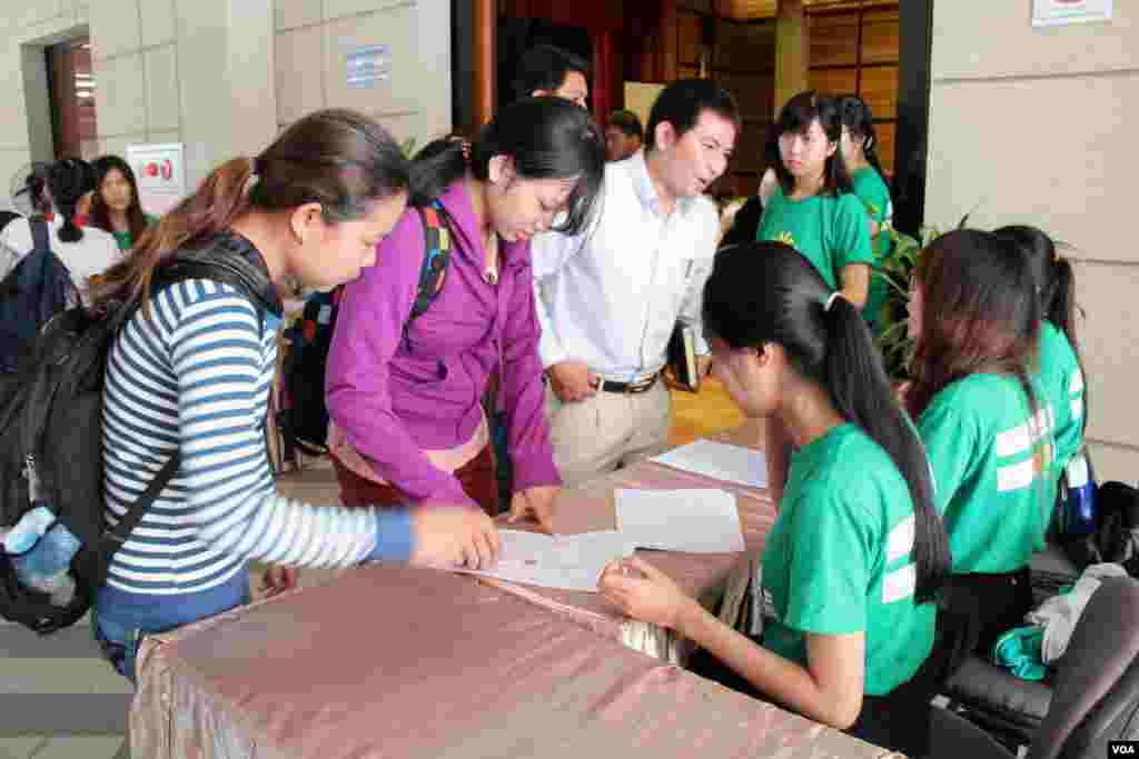 អ្នកចូលរួមកំពុងចុះឈ្មោះក្នុងវេទិកាសាធារណៈដែលពិភាក្សាអំពីការអភិវឌ្ឍប្រកបដោយចីរភាព នៅមជ្ឈមណ្ឌលសហប្រតិបត្តិការកម្ពុជា ជប៉ុន កាលពីថ្ងៃសៅរ៍ ទី២៣ ខែសីហា ឆ្នាំ២០១៤។ (នូវ ពៅលក្ខិណា VOA)