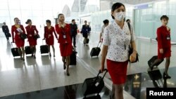 香港國泰航空公司的空姐在2003年中國非典疫情期間戴口罩上班。（2003年5月15日）