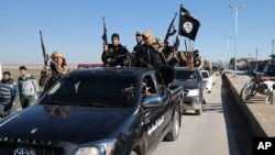 Islamic State militants pass by a convoy in Tel Abyad town, northeast Syria, in this photo released May 4, 2015, by a militant website.