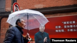 召開前夕，一名男子在上海街頭一幅有習近平像的宣傳板前走過。