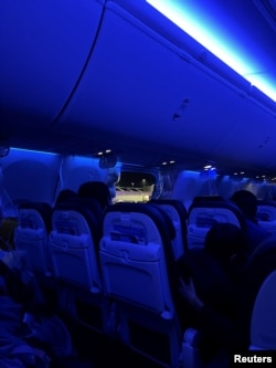 People sit on a plane next to a missing window and portion of a side wall of an Alaska Airlines Flight 1282, which had been bound for Ontario, California, from Portland, Oregon, on Jan. 5, 2024. (Instagram/@strawberrvy via Reuters)