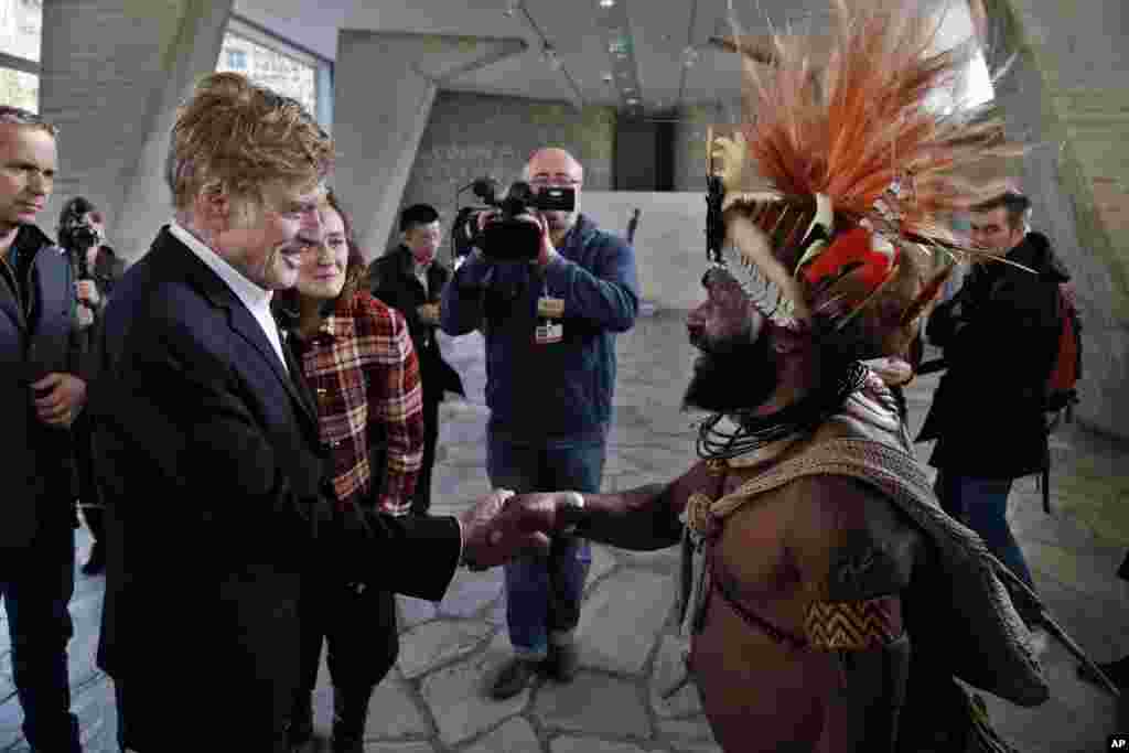 Un chef de la tribu Huli de Papouasie-Nouvelle-Guinée, Mundiya Kepanga, à droite, se serre la main avec l'acteur américain et militant écologiste Robert Redford, avant une conférence sur le climat, au siège de l'UNESCO, à Paris, 6 décembre 2015. 