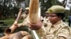 Kenya Wildlife Service officials carry recovered elephants tusks and illegally held firearms from poachers in this file photo.