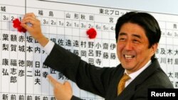 資料照- 本照片攝於2003年11月9日。當時作為執政的日本自民黨總幹事的安培晉三正幫著記錄本黨參選人的進展情況，每當本黨參選人獲勝，安倍就在他們的名字上面插一朵小花。67歲的日本前首相安倍晉三星期五（7月8日）在奈良遭槍擊，因傷勢過重，不治身亡。（路透社）