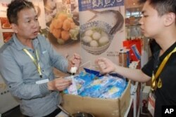 廣州市民歐先生(右)試吃台灣花枝丸