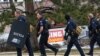 Des agents des forces de l'ordre balaient le parking sur le lieu d'une fusillade dans une épicerie King Soopers à Boulder, Colorado, États-Unis, le 22 mars 2021. 