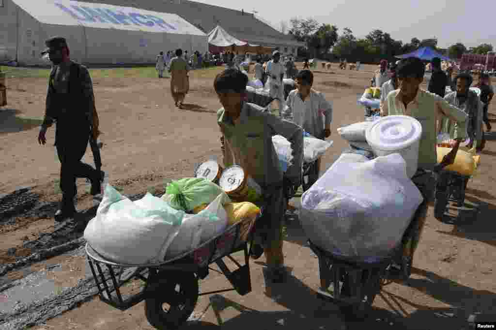 Des garçons a reçu une tente de stockage du Programme alimentaire mondial (PAM) à un point de distribution alimentaire dans le Nord Waziristan.