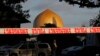 A police officer stands guard in front of the Masjid Al Noor mosque in Christchurch, New Zealand, Sunday, March 17, 2019, where one of the two mass shootings occurred. New Zealand's stricken residents reached out to Muslims in their neighborhoods and arou