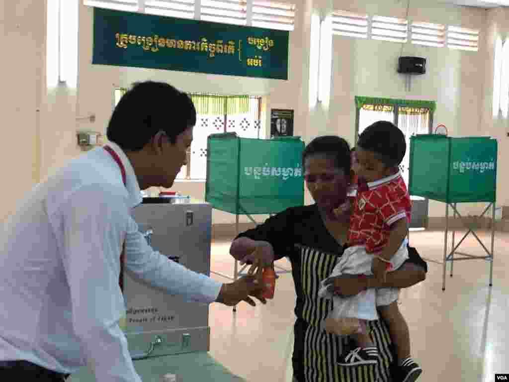 ស្ត្រីកម្ពុជាម្នាក់បោះឆ្នោតជ្រលក់ម្រាមដៃនៅក្រោយការបោះឆ្នោតនៅការិយាល័យ «សាលាគរុកោសល្យវិក្រិត្យការក្រុង» សង្កាត់តាខ្មៅ ក្រុងតាខ្មៅ ខេត្តកណ្តាល កាលពីព្រឹកថ្ងៃអាទិត្យ ទី២៩ ខែកក្កដា ឆ្នាំ២០១៨។ (សុខ ខេមរា/VOA)